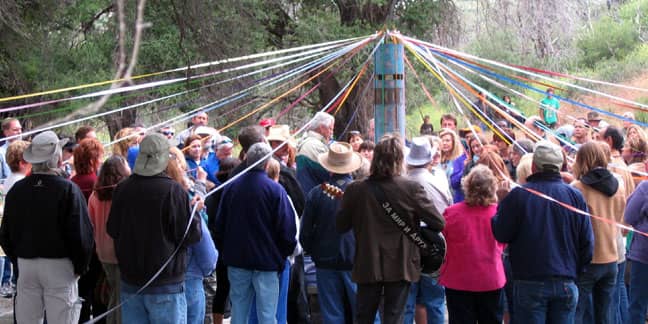 Custom Bronze and Copper peace pole surrounded by a crowd at the dedication ceremony with ribbons for each language strung out over their heads